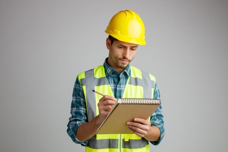 Técnico industrial registrando datos de ficha técnica antes de aprobar compra
